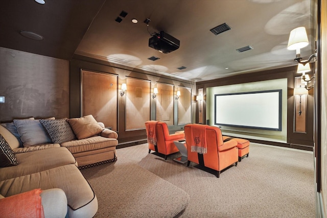 carpeted home theater featuring visible vents, crown molding, and a decorative wall