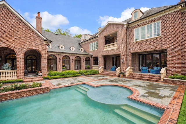 outdoor pool with a patio area and french doors