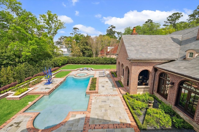 view of pool with a fenced in pool, a yard, a patio, and an in ground hot tub