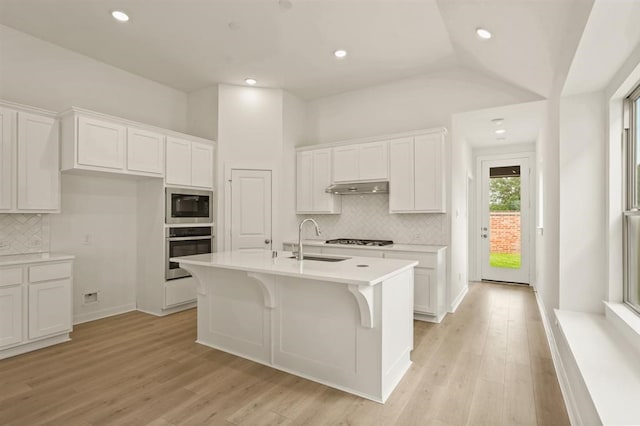 4918 Shore Arbor Ln, Katy, TX 77493 - kitchen with stainless steel oven, a sink, decorative backsplash, under cabinet range hood, and recessed lighting
