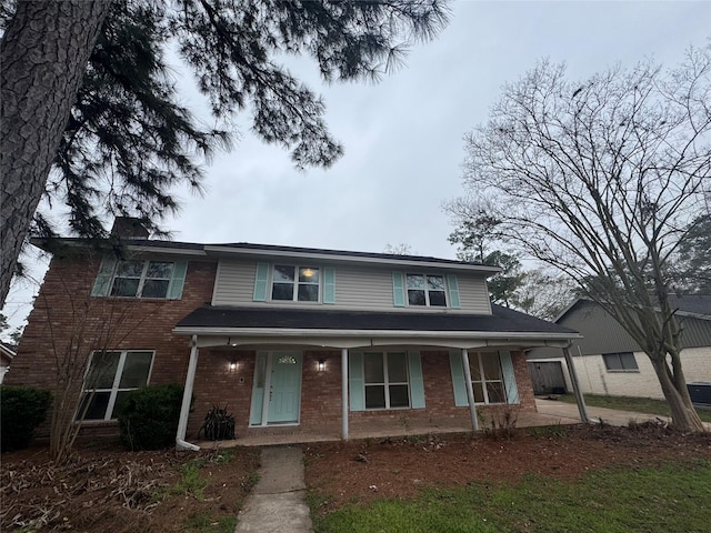 view of front of home featuring covered porch and brick siding