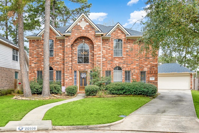 traditional-style house featuring a garage, brick siding, a front lawn, and roof with shingles