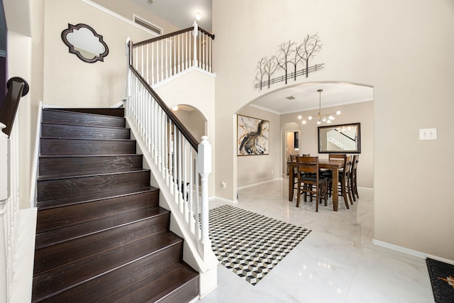 stairs featuring crown molding, marble finish floor, arched walkways, and baseboards