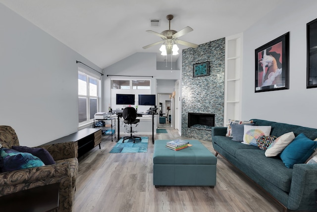 living room featuring a ceiling fan, vaulted ceiling, wood finished floors, and visible vents