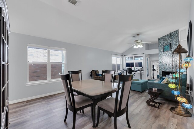 dining space with a wealth of natural light, visible vents, a ceiling fan, and vaulted ceiling