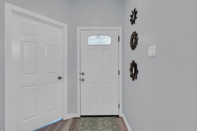 doorway to outside with dark wood-type flooring and baseboards