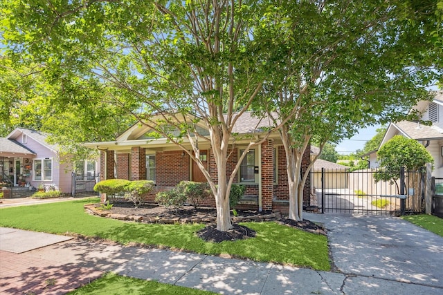 view of front facade featuring brick siding, concrete driveway, a front yard, and fence