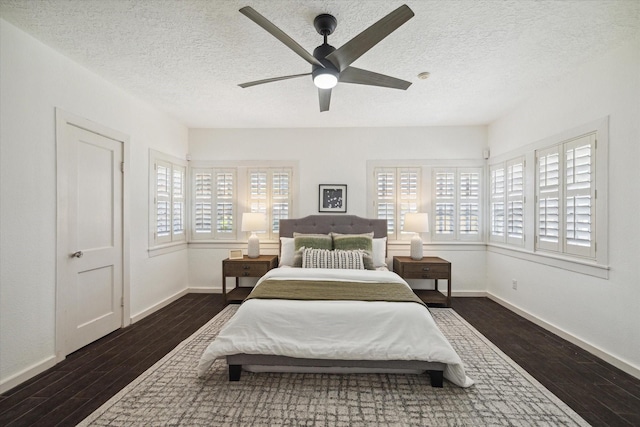 bedroom featuring ceiling fan, wood finished floors, baseboards, and a textured ceiling