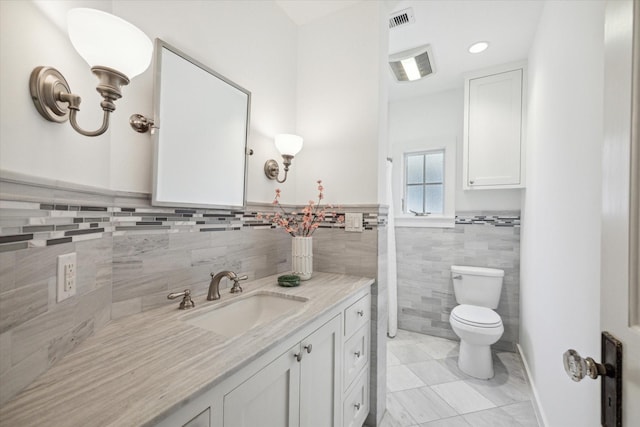 bathroom with vanity, toilet, and visible vents