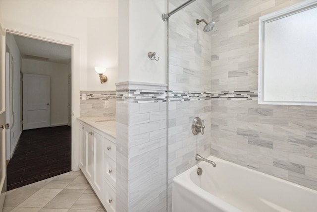 full bath featuring bathing tub / shower combination, tile walls, vanity, and tile patterned flooring