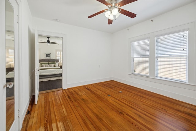 empty room with hardwood / wood-style flooring, baseboards, and ceiling fan