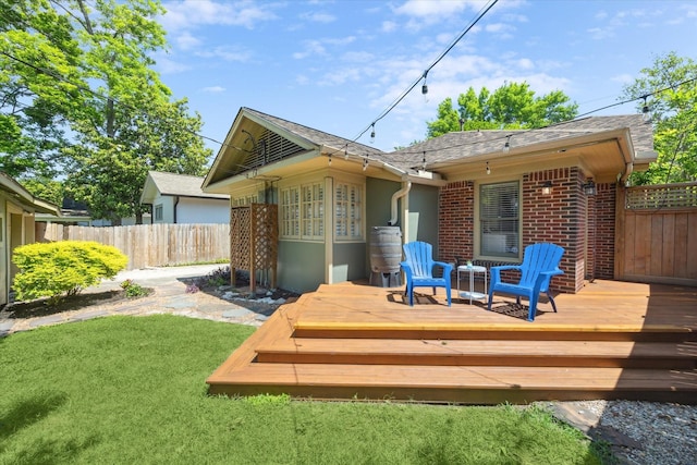 wooden terrace featuring fence and a lawn