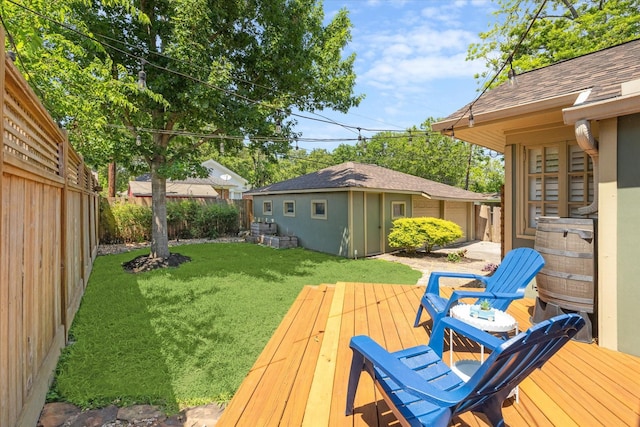 deck featuring an outdoor structure, a fenced backyard, and a lawn