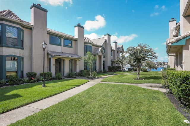 view of home's community featuring a water view and a yard