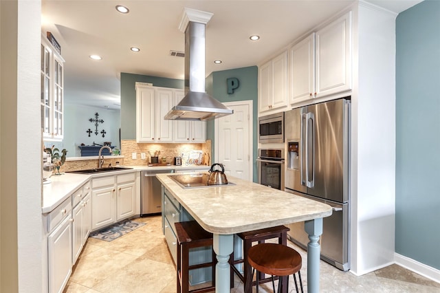 kitchen featuring a breakfast bar, a center island, appliances with stainless steel finishes, a sink, and island range hood