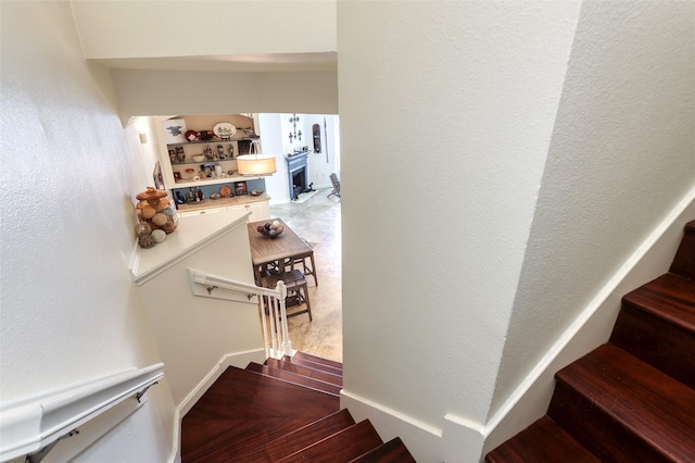 stairs featuring a textured wall and wood finished floors