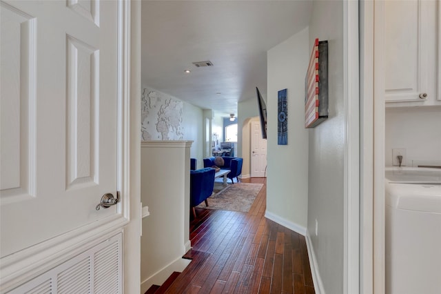 hallway featuring washer / dryer, visible vents, dark wood finished floors, and baseboards