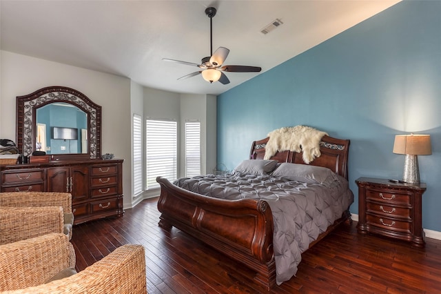 bedroom with dark wood-type flooring, visible vents, ceiling fan, and baseboards