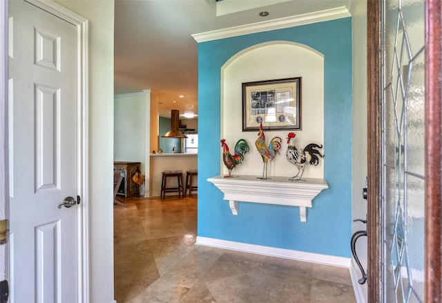 foyer with baseboards and crown molding