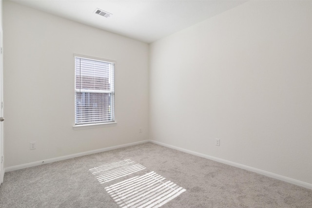 carpeted empty room with visible vents and baseboards