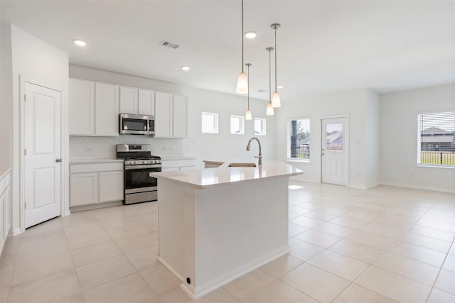 kitchen with a sink, visible vents, light countertops, appliances with stainless steel finishes, and backsplash