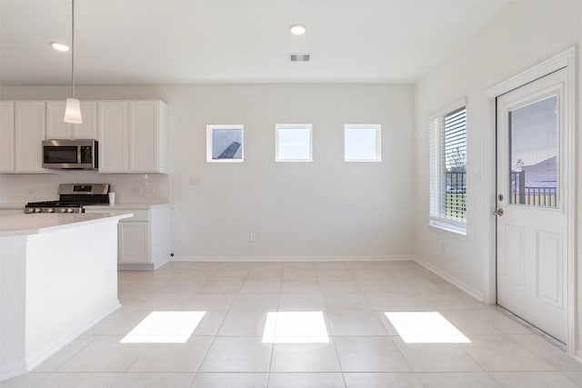 kitchen with baseboards, visible vents, appliances with stainless steel finishes, light countertops, and backsplash