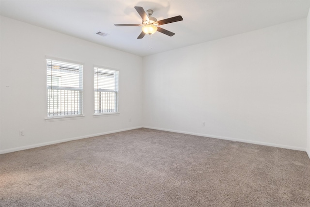 empty room featuring carpet, visible vents, ceiling fan, and baseboards