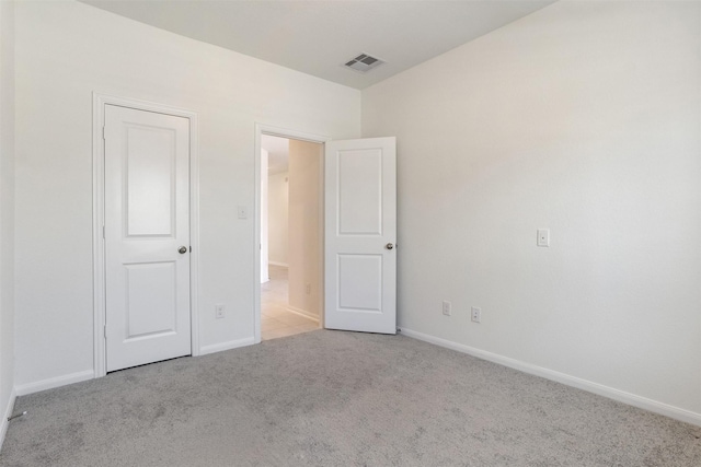 unfurnished bedroom featuring baseboards, visible vents, and carpet flooring