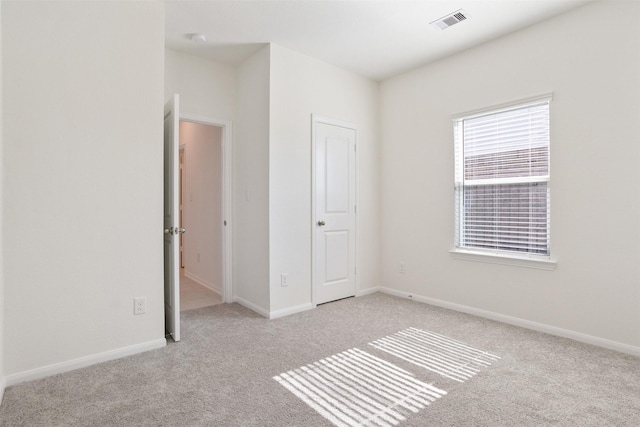 unfurnished bedroom featuring carpet floors, visible vents, and baseboards