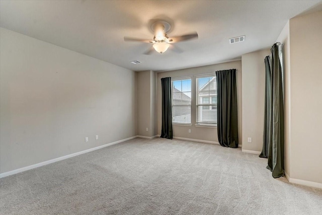 unfurnished room featuring baseboards, visible vents, light colored carpet, and ceiling fan