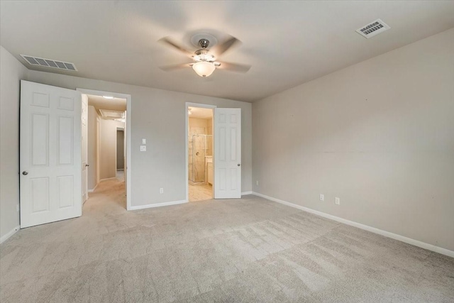 unfurnished bedroom with baseboards, ensuite bathroom, visible vents, and carpet flooring