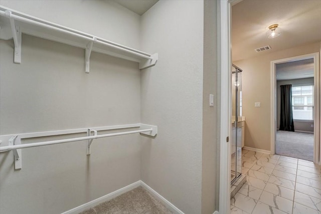 spacious closet with marble finish floor and visible vents
