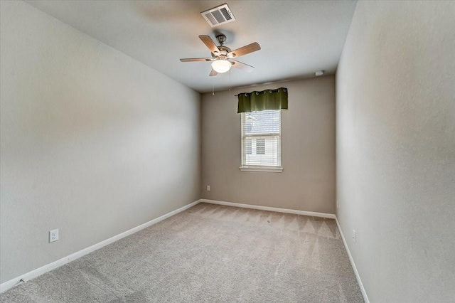 spare room with ceiling fan, visible vents, baseboards, and light carpet
