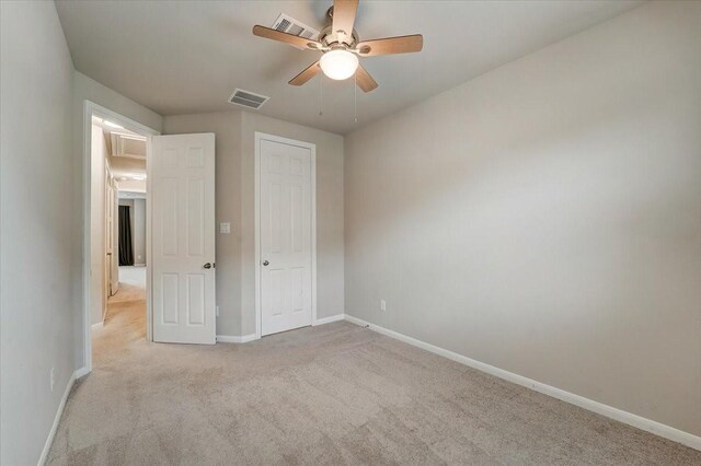 unfurnished bedroom featuring ceiling fan, carpet floors, visible vents, and baseboards
