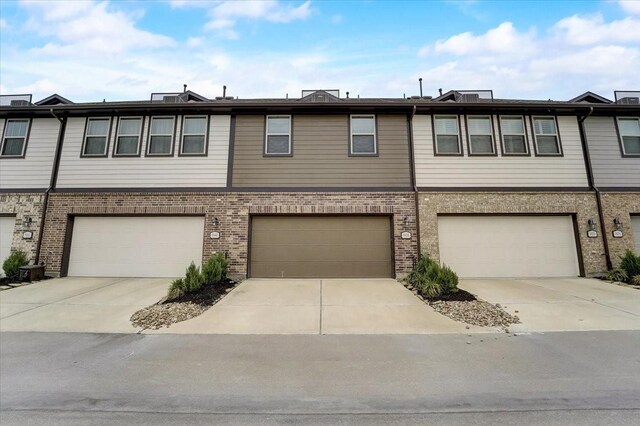 view of front of house with brick siding, concrete driveway, and a garage