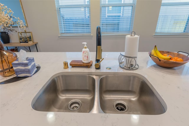 interior details with light stone counters and a sink