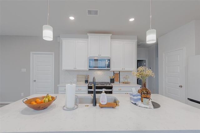 kitchen featuring stainless steel appliances, visible vents, white cabinets, a large island, and backsplash