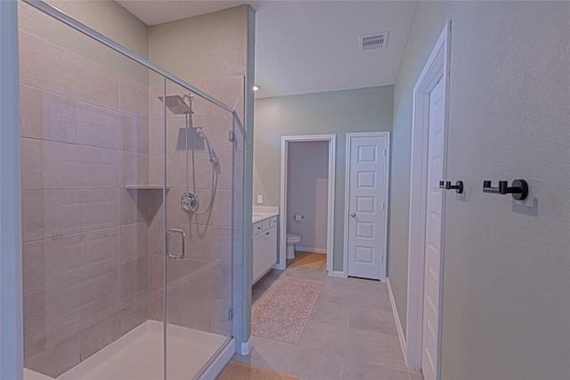 bathroom featuring a stall shower, baseboards, visible vents, toilet, and vanity