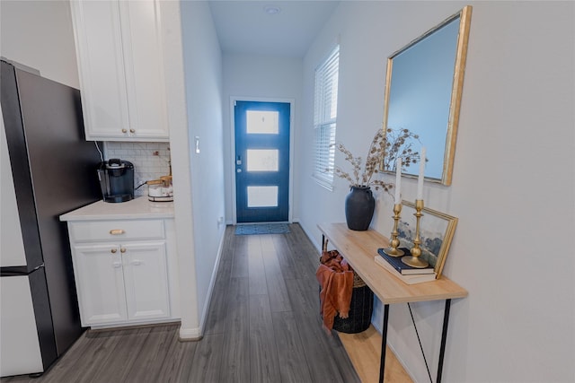 entryway with wood finished floors and baseboards