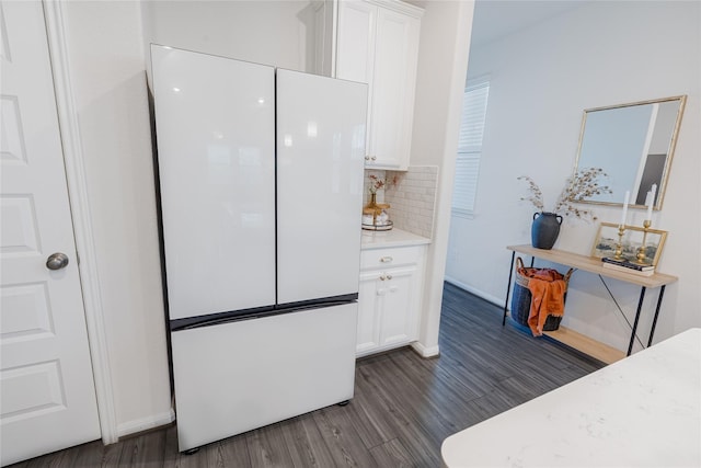 kitchen with decorative backsplash, white cabinets, dark wood-style floors, freestanding refrigerator, and light countertops