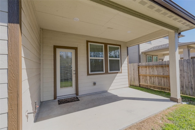 property entrance featuring a patio area and fence