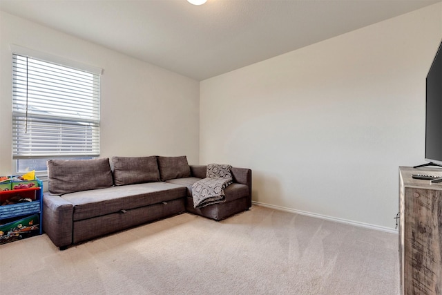 carpeted living area featuring baseboards