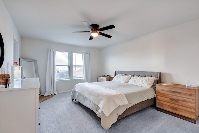 bedroom featuring light carpet, a ceiling fan, and baseboards