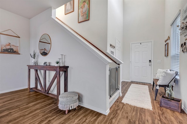 foyer featuring stairway, baseboards, and wood finished floors