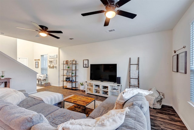 living room with visible vents, ceiling fan, baseboards, and wood finished floors