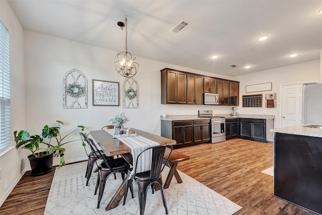 kitchen featuring visible vents, appliances with stainless steel finishes, light wood-style flooring, and dark brown cabinets