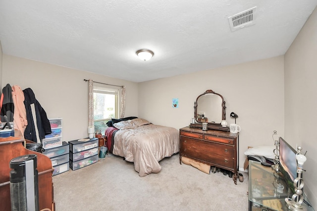 bedroom featuring a textured ceiling, visible vents, and carpet flooring