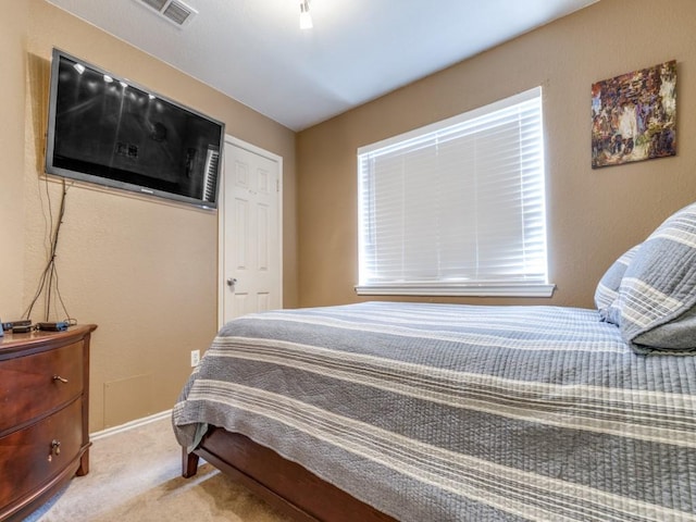 bedroom featuring baseboards, visible vents, and light colored carpet