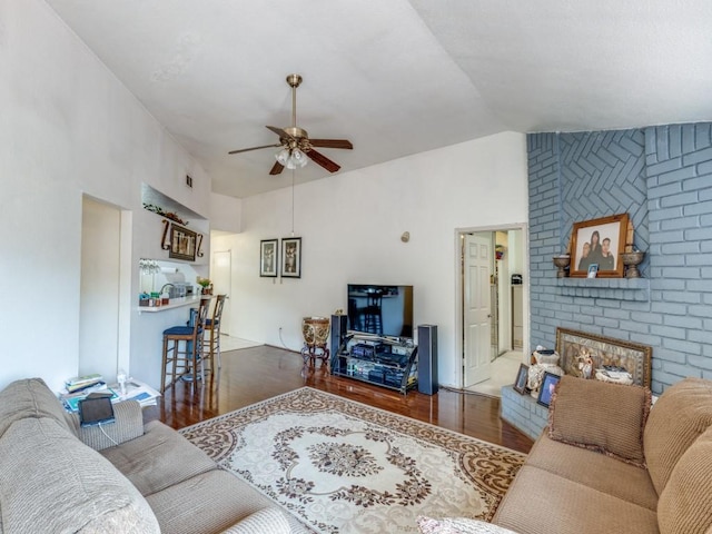 living area with lofted ceiling, ceiling fan, and wood finished floors