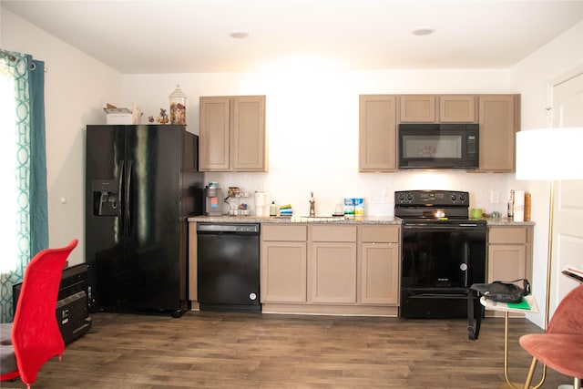 kitchen with dark wood-type flooring, light stone counters, and black appliances